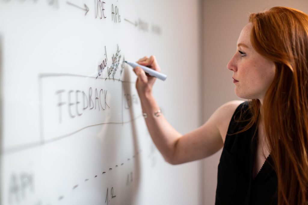 A photo of a website developer plans around the word “Feedback” written on a whiteboard.